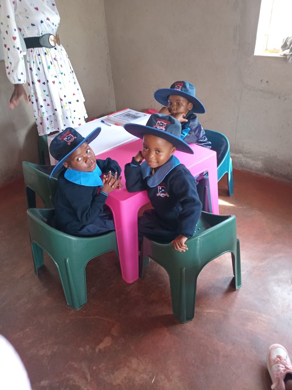 Learners smiling at their classroom table