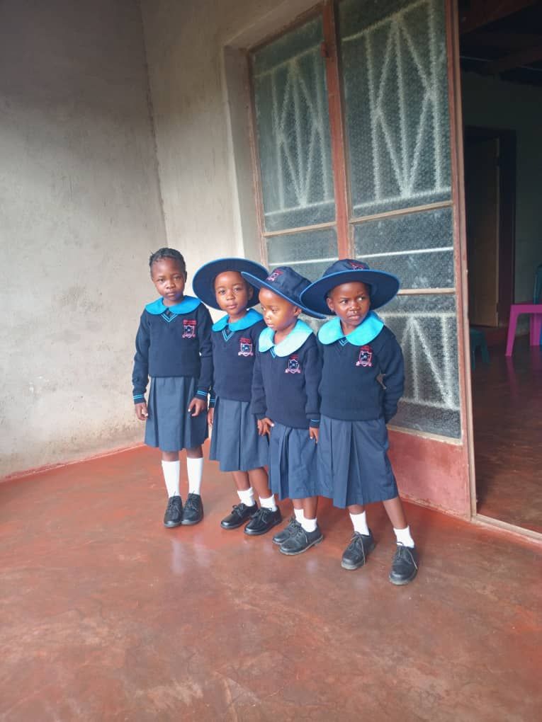 Four learners standing proudly in Bright Beginners uniform
